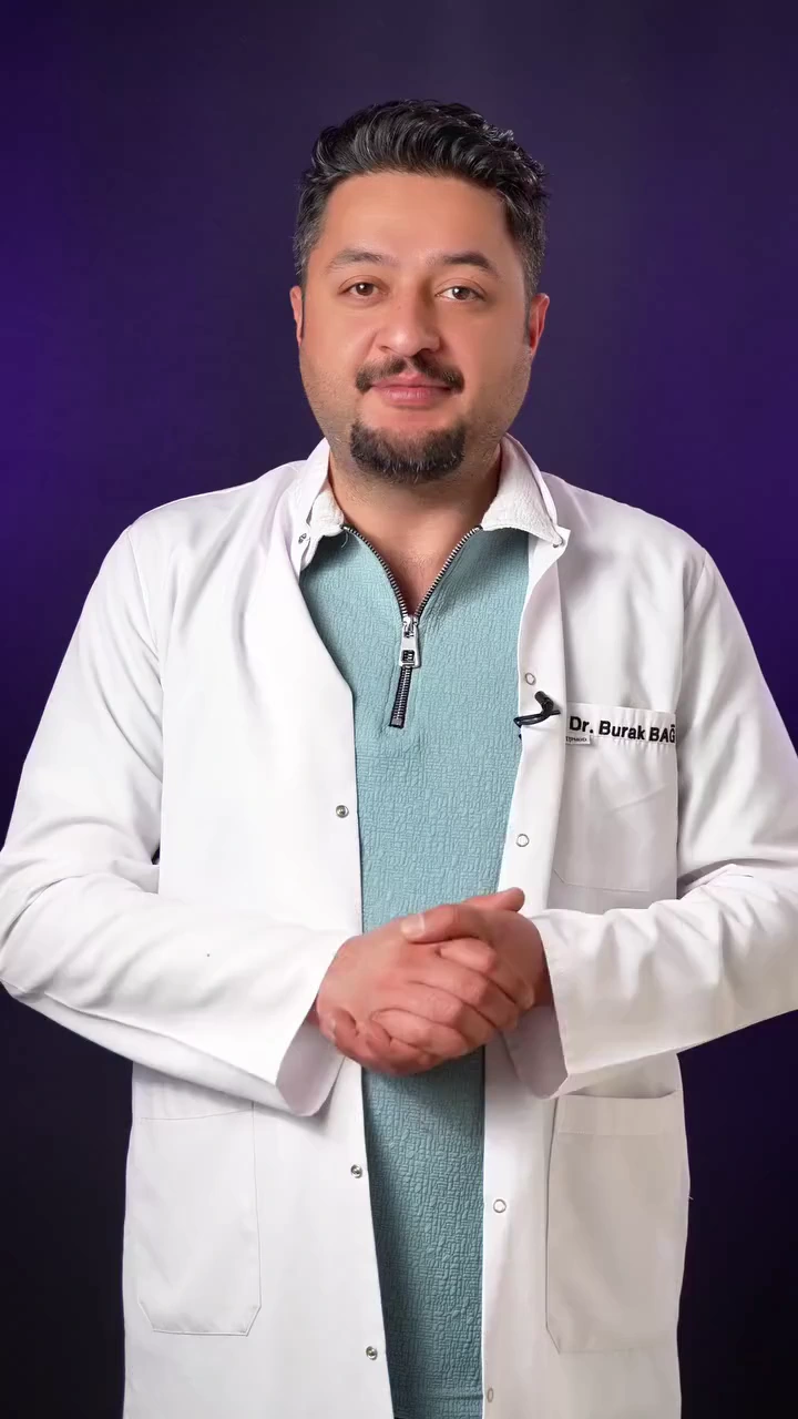 Dr. Burak Bağ, beyaz önlüğüyle koyu fon önünde kamera karşısında.